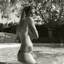 Ireland Baldwin seins nus au bord de la piscine
