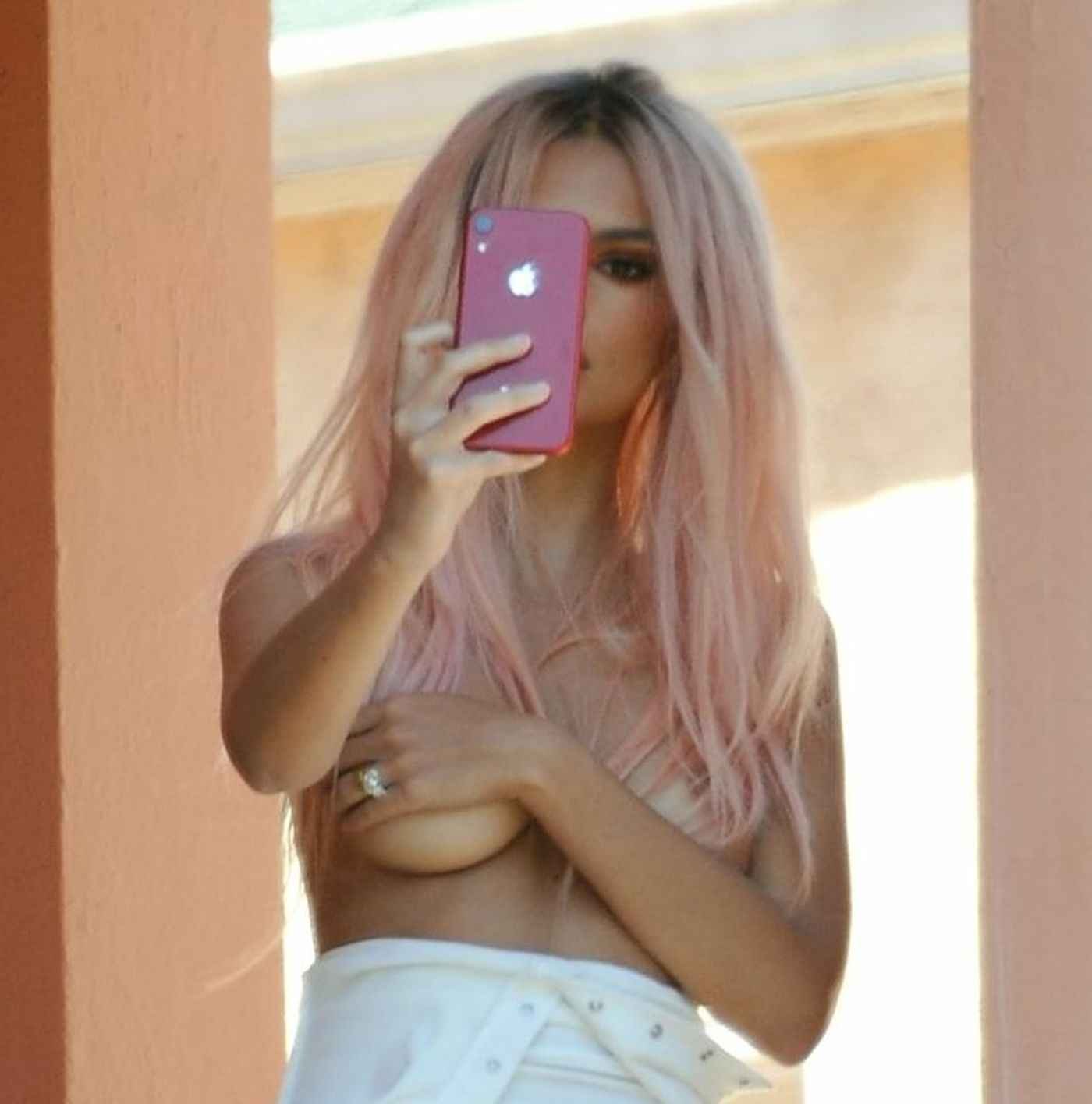 Emily Ratajkowski fait des photos seins nus sur un balcon