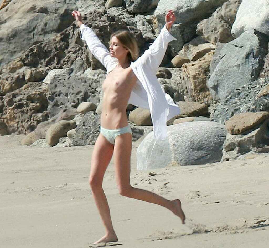 Stella Maxwell seins nus et en petite culotte à la plage