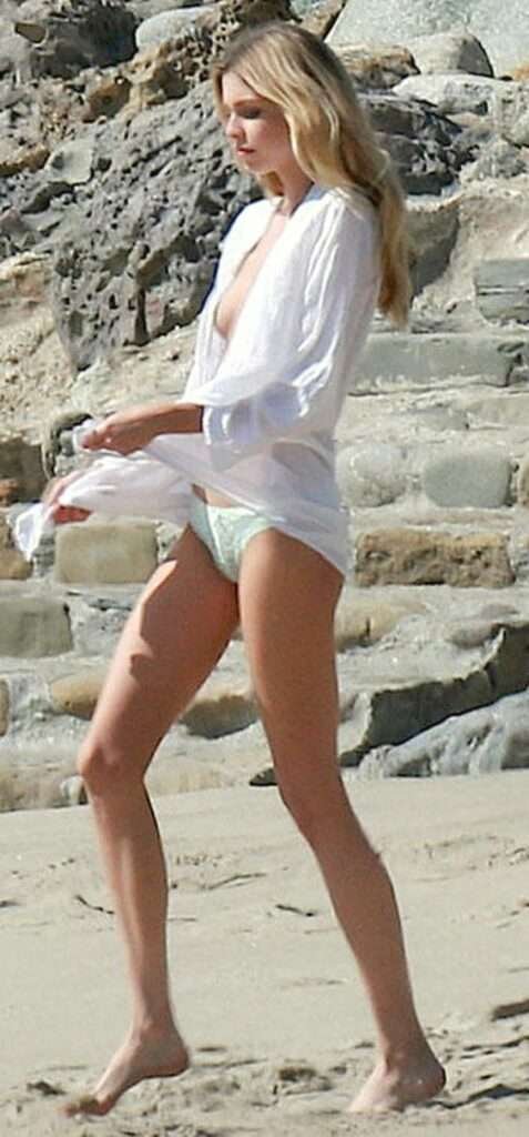Stella Maxwell seins nus et en petite culotte à la plage