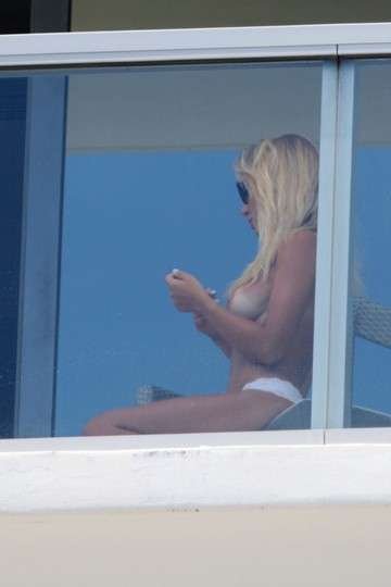 Laura Cremaschi montre ses seins sur le balcon