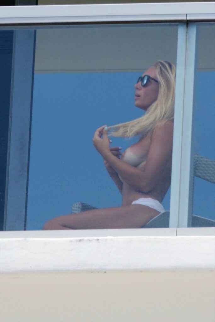 Laura Cremaschi montre ses seins sur le balcon